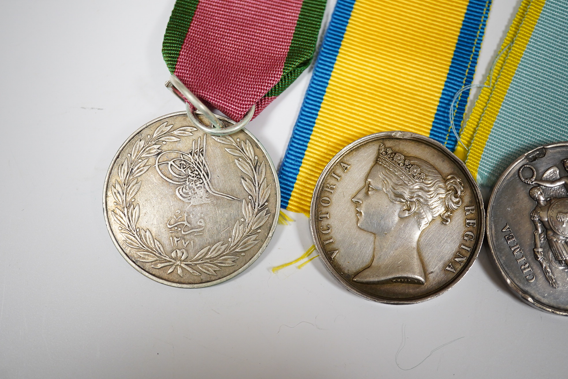 Two Crimea medals, a Baltic medal, all disc only and unnamed with a replica Turkish Crimea medal, unnamed, (3).